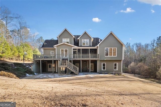 back of house featuring a sunroom and a wooden deck