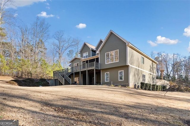 back of property with a lawn and a wooden deck