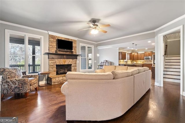 living room featuring a fireplace, ornamental molding, and dark hardwood / wood-style floors