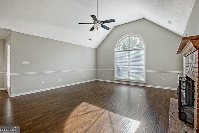 unfurnished living room featuring a fireplace, a textured ceiling, lofted ceiling, ceiling fan, and dark hardwood / wood-style flooring