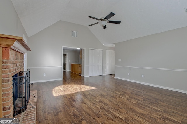 unfurnished living room with a fireplace, high vaulted ceiling, ceiling fan, and dark hardwood / wood-style flooring