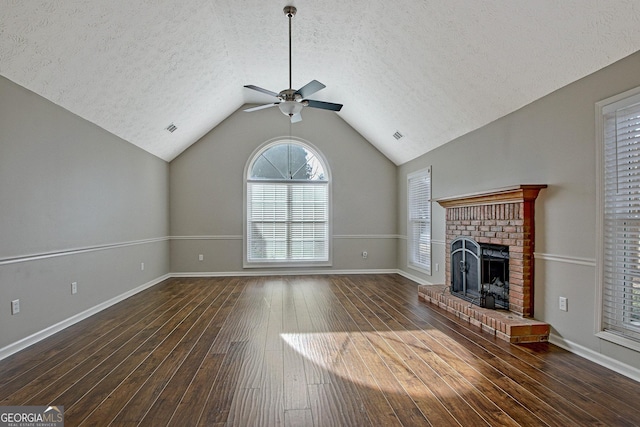 unfurnished living room with ceiling fan, dark wood-type flooring, a fireplace, a textured ceiling, and lofted ceiling