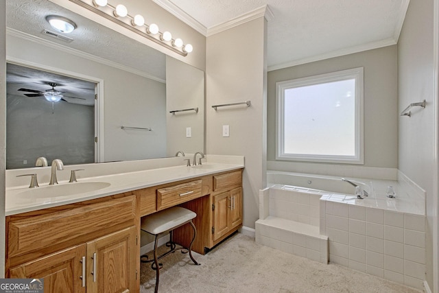 bathroom with a textured ceiling, ceiling fan, tiled bath, and vanity