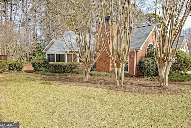 view of front of home featuring a front lawn and a sunroom