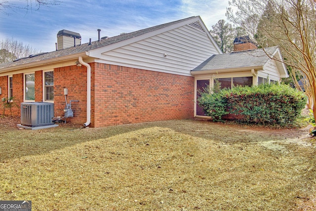 view of home's exterior featuring central AC unit and a lawn