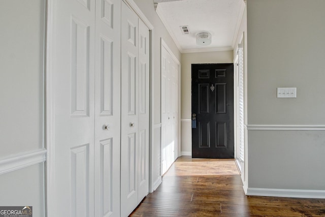 doorway to outside featuring hardwood / wood-style flooring, ornamental molding, and a healthy amount of sunlight