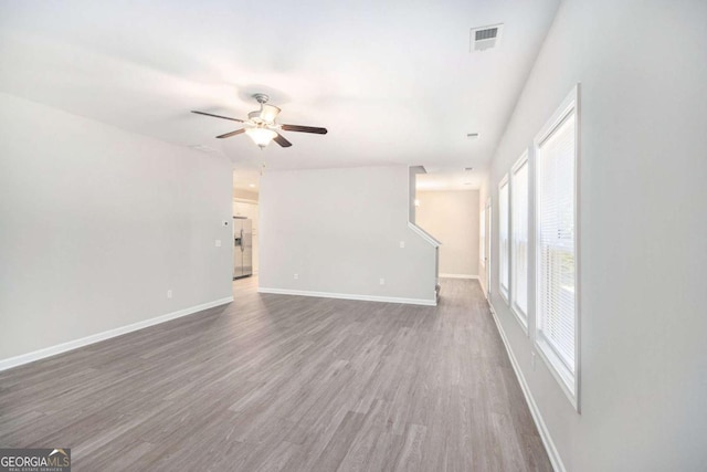 spare room with dark hardwood / wood-style flooring and ceiling fan