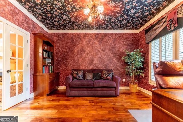 living area with hardwood / wood-style floors and crown molding