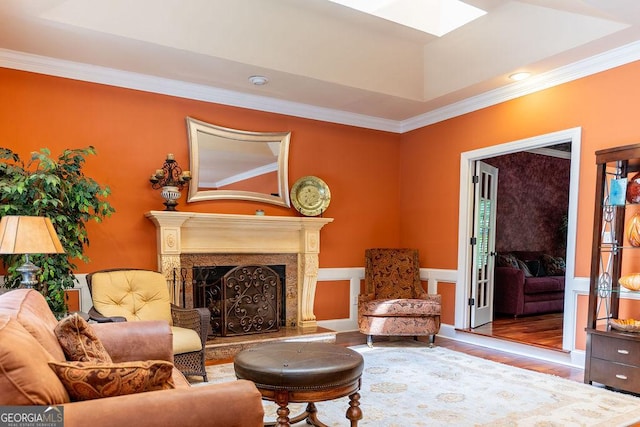 living area featuring hardwood / wood-style floors, crown molding, a fireplace, and a tray ceiling