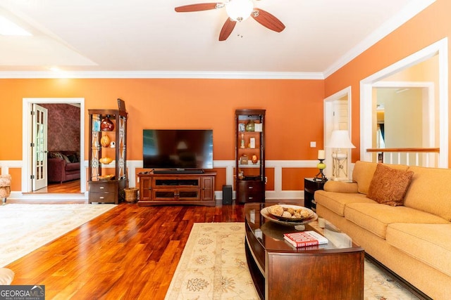 living room with wood-type flooring, ceiling fan, and crown molding