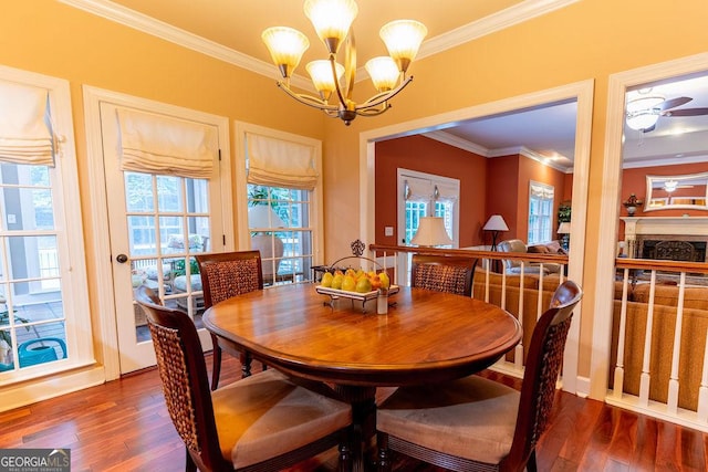 dining room with ceiling fan with notable chandelier, dark hardwood / wood-style flooring, and crown molding