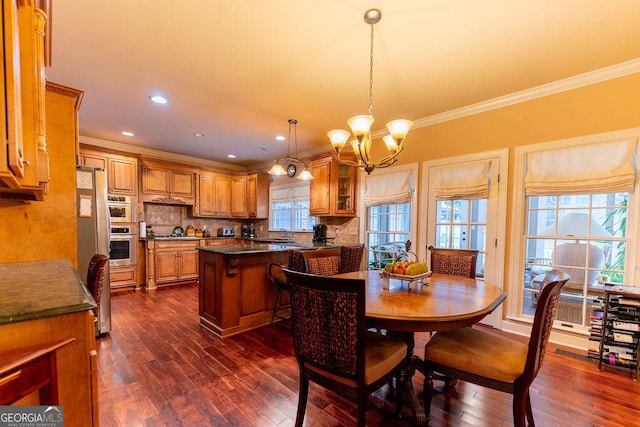 dining space featuring dark hardwood / wood-style flooring, crown molding, and a notable chandelier