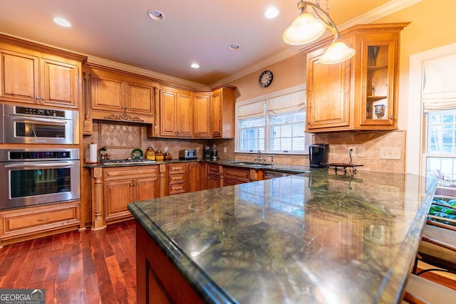 kitchen with hanging light fixtures, crown molding, tasteful backsplash, and stainless steel appliances