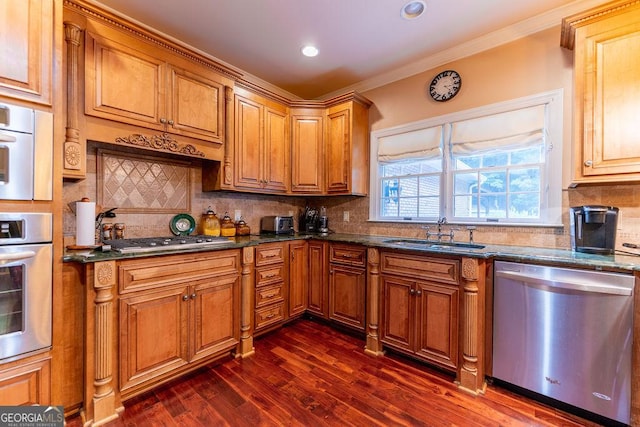 kitchen featuring sink, dark stone countertops, backsplash, dark hardwood / wood-style floors, and appliances with stainless steel finishes