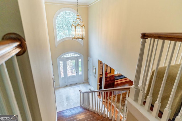 foyer with an inviting chandelier and ornamental molding