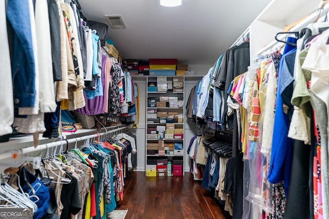 walk in closet with dark wood-type flooring