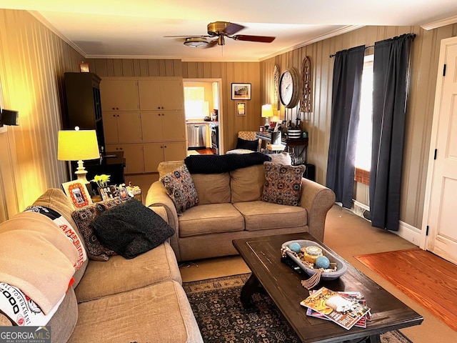 living room with crown molding, ceiling fan, and wood walls