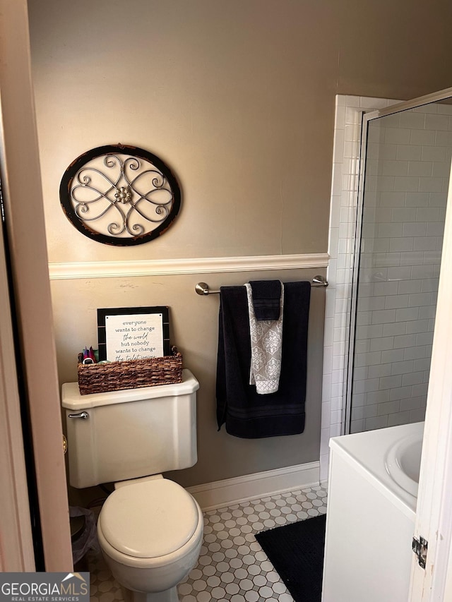 bathroom with a tile shower, vanity, and toilet