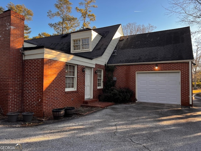 314 Cherokee Rd, Thomaston, GA 30286 - new england style home with brick siding, a shingled roof, an attached garage, and asphalt driveway