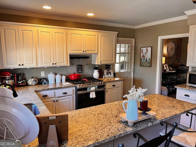 314 Cherokee Rd, Thomaston, GA 30286 - kitchen featuring range with gas cooktop, a breakfast bar area, light stone countertops, white cabinetry, and crown molding