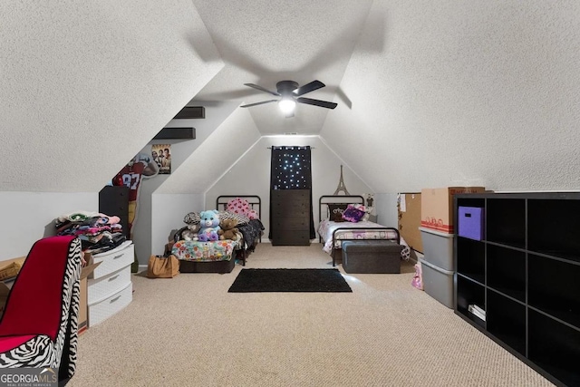 bedroom with lofted ceiling, carpet flooring, a textured ceiling, and ceiling fan