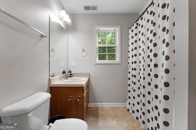 bathroom featuring vanity, curtained shower, and toilet