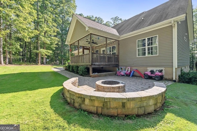 back of house featuring a lawn, a fire pit, ceiling fan, and a patio area