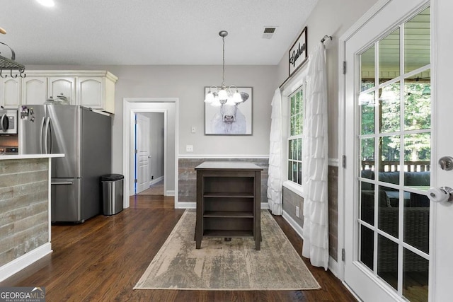 kitchen with decorative light fixtures, dark hardwood / wood-style flooring, white cabinets, and appliances with stainless steel finishes