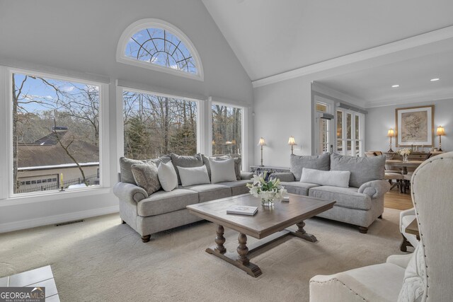 living room featuring a healthy amount of sunlight, crown molding, light carpet, and high vaulted ceiling