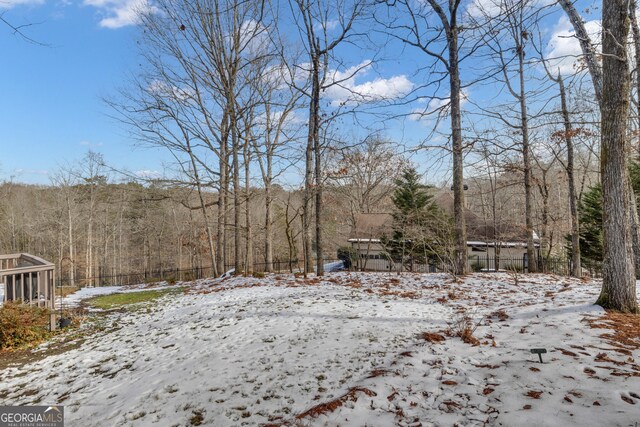 snow covered back of property featuring a deck