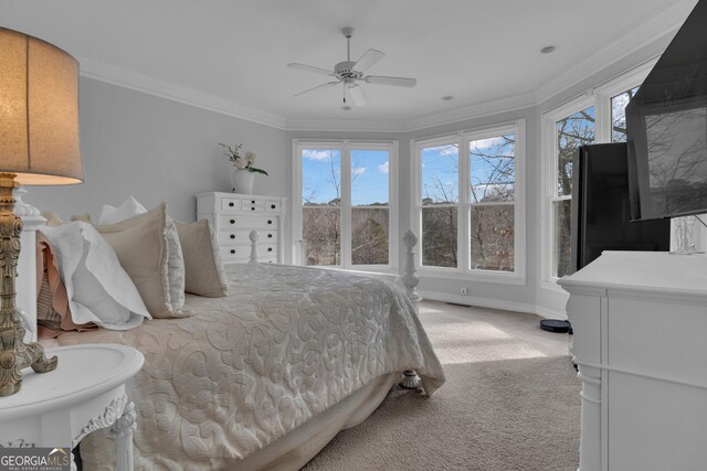 carpeted bedroom featuring ceiling fan and crown molding