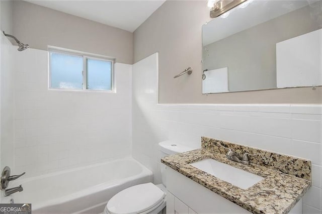 full bathroom with toilet, vanity, tile walls, and tiled shower / bath