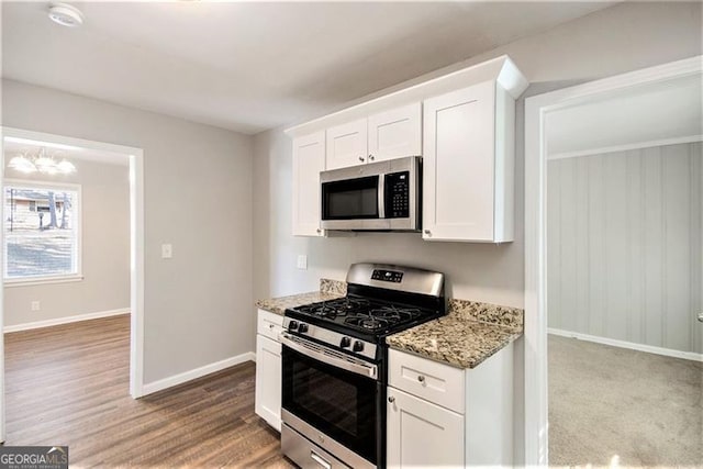 kitchen featuring light stone counters, appliances with stainless steel finishes, and white cabinetry