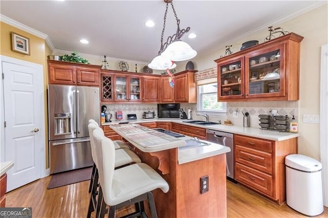 kitchen with pendant lighting, a center island, stainless steel appliances, backsplash, and sink