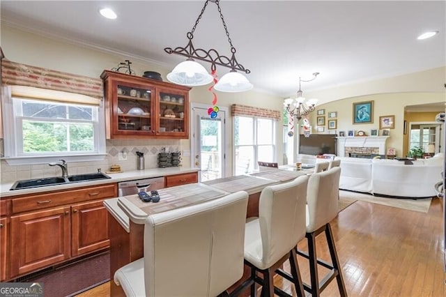 kitchen featuring a breakfast bar area, a center island, sink, decorative light fixtures, and backsplash