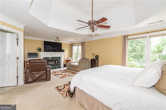 carpeted bedroom featuring a raised ceiling, ceiling fan, and crown molding