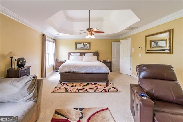 bedroom featuring ceiling fan, a tray ceiling, crown molding, and light carpet