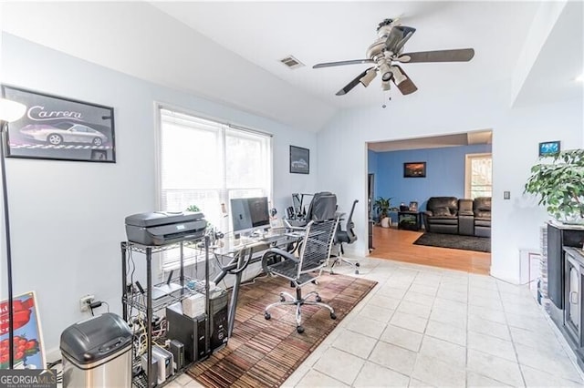 home office featuring ceiling fan, lofted ceiling, and light tile patterned floors