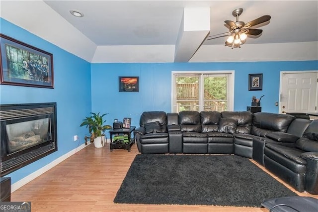 living room with ceiling fan, hardwood / wood-style floors, and a tray ceiling