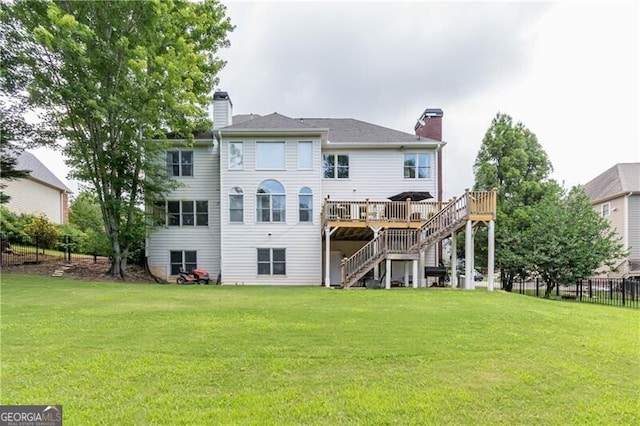 back of property with a deck and a lawn