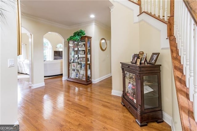 2080 Misty Oaks Dr, Buford, GA 30519 - hall with arched walkways, stairs, wood finished floors, crown molding, and baseboards