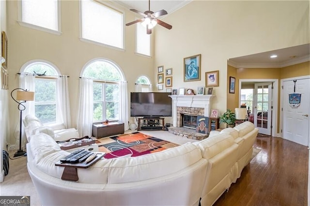 living room with a high ceiling, ceiling fan, and a wealth of natural light