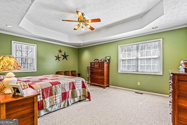 carpeted bedroom featuring ceiling fan, multiple windows, a raised ceiling, and a textured ceiling