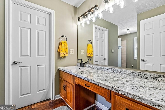 bathroom with hardwood / wood-style floors, a textured ceiling, and vanity