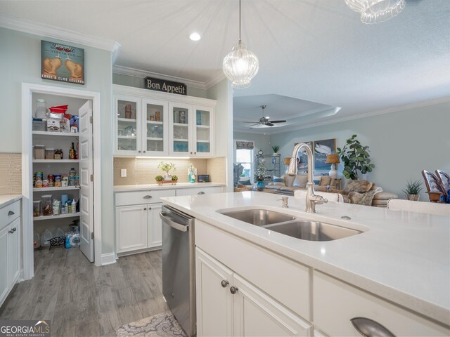 kitchen featuring white cabinets, stainless steel dishwasher, pendant lighting, and sink