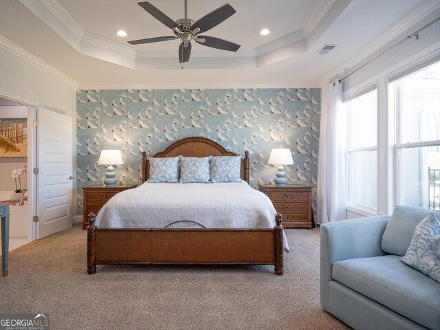 bedroom with ceiling fan, light colored carpet, ornamental molding, and a raised ceiling