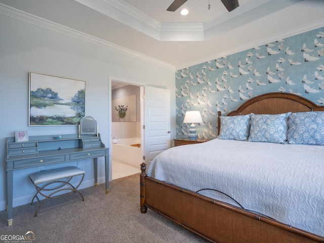 carpeted bedroom with ensuite bath, a raised ceiling, ceiling fan, and crown molding