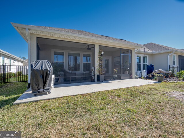 back of property with ceiling fan, a yard, a sunroom, and a patio area