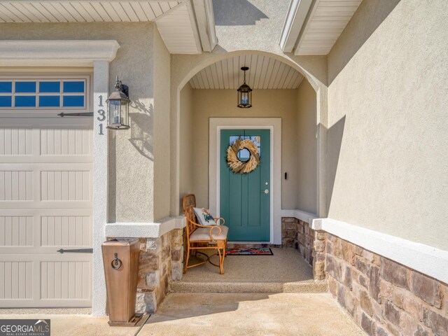 131 Ryan Nicholas Dr, Kingsland, GA 31548 - doorway to property featuring stucco siding, stone siding, and a garage