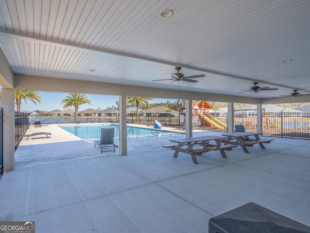 view of pool with a patio, ceiling fan, and a playground